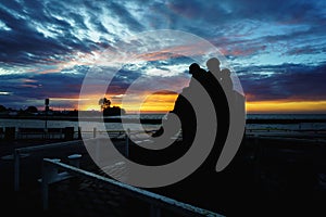 Wide shot of the silhouette of Fisherman's Memorial, Port Dover in Ontario Canada during sunset