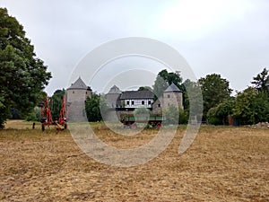 Wide shot of a stone house and some equipment on the field in Ratingen, Germany
