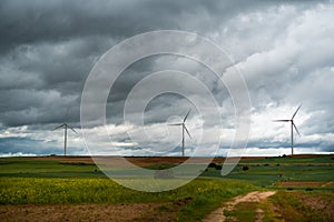 Wide Shot Of Sustainable Wind Turbines or Windmills At A Farm field In Valdorros In Castile and Leon, Burgos, Spain. Cloudy epic