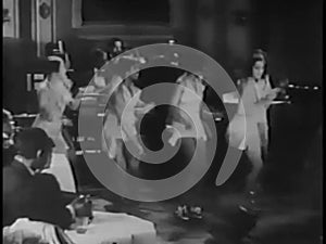 Wide shot of tap dancers performing in nightclub, 1930s