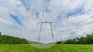 Wide shot timelapse of electricity power lines and high voltage pylons.