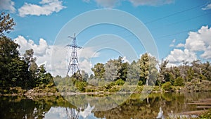 Wide shot timelapse of electricity power lines and high voltage pylons on a field in the countryside at summer near
