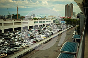 Wide shot of vehicles parked in a parking lot near a building under construction