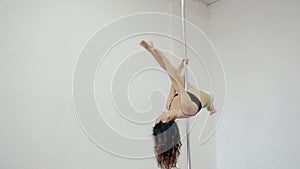 Wide shot Young girl dancing poledance in white room