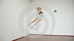 Wide shot Young girl dancing poledance in white room