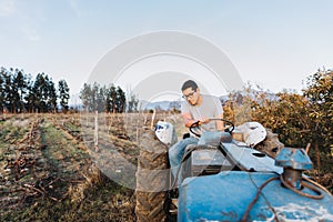 Latin farmer man driving an old tractor, in the middle of his farmland.