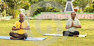 wide shoto of Senior man in namaste pose on yoga mat - concept of Elderly 60s people fitness, healthy lifestyle and