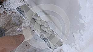 Spatula with thick mortar in the hand of the builder