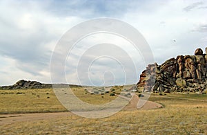 Wide steppe with yellow grass under a blue sky with white clouds Sayan mountains Siberia Russia