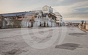 wide street in the suburbs of the city with abandoned warehouse and factory