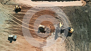Wide top down shot footage. Excavator loads sand into mining truck. Mining Excavator loads sand rock into haul truck