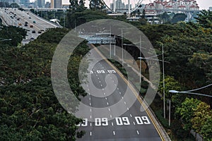 Wide urban freeway Asian metropolis. Modern buildings and structures. Singapore. Highway in dense rainforest