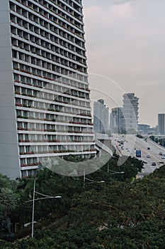 Wide urban freeway Asian metropolis. Modern buildings and structures. Singapore. Highway in dense rainforest