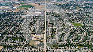 Wide view from above of subdivisions and streets with trees