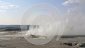 Wide view of clepsydra geyser erupting in yellowstone