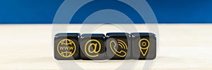 Wide view of customer service image with black dices with gold contact information and location icons on them