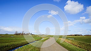 Wide view on Dutch landscape with meadow and cloudy skies