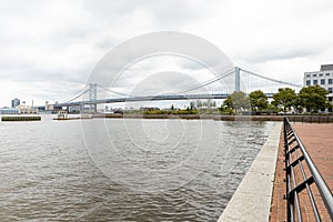 Wide view of the entire Benjamin Franklin Bridge from behind a railing on the Camden Waterfront, New Jersey, USA