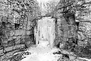Wide view of frozen cascading waterfall cutting its way through