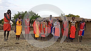 Wide view of a group of ten maasai women and men singing