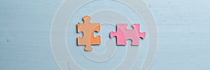 Wide view image of two blank orange and pink matching puzzle pieces