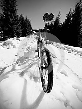 Wide view photo of mountain bike in deep snow. Winter mountains with road
