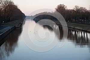 Wide view on a river with trees and the  tree reflection in fresenburg emsland germany