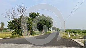 Wide view of rural road with no vehicles and living beings photo