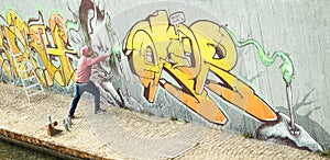 Wide viewof street artist painting colorful graffiti on generic