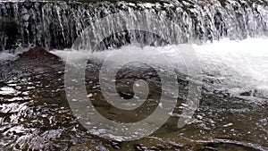 Wide waterfall on a mountain river in dark summer day foamed water falling waterfall