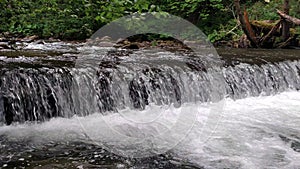 Wide waterfall on a mountain river in dark summer day Foamed water Falling waterfall