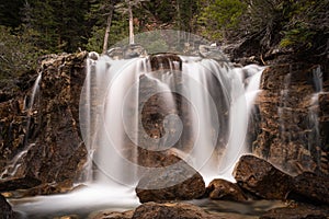 A wide waterfall with rocks in the foreground