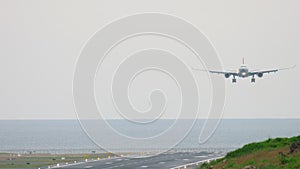 Widebody aircraft approaching over ocean