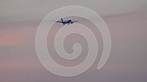 Widebody airplane final approaching at sunset