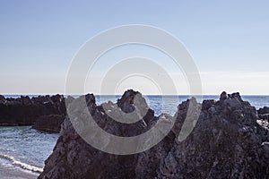 Widescreen Seascape with Rocks, Stones and Waves. Sea Waves Impact Rocks on the Beach. Rays of the Sun Play on the Surface of the