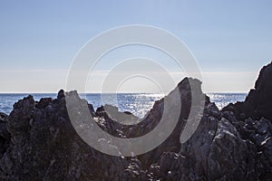 Widescreen Seascape with Rocks, Stones and Waves. Sea Waves Impact Rocks on the Beach. Rays of the Sun Play on the Surface of the