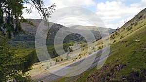 Widescreen view along steep grassy bank