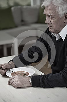 Widower eating meal