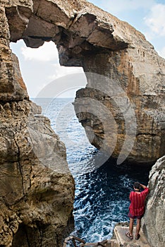 Wied il Mielah canyon, natural arch over the sea. Gozo, Malta