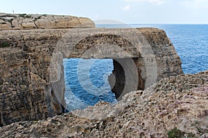 Wied il Mielah canyon, natural arch over the sea. Gozo, Malta