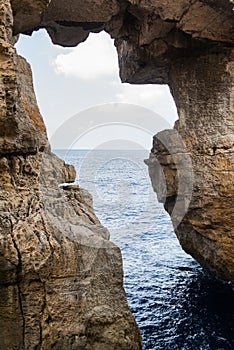 Wied il Mielah canyon, natural arch over the sea. Gozo, Malta