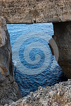 Wied il Mielah canyon, natural arch over the sea. Gozo, Malta