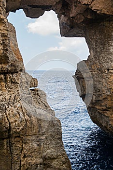 Wied il Mielah canyon, natural arch over the sea. Gozo, Malta