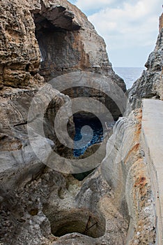 Wied il Mielah canyon, natural arch over the sea. Gozo, Malta