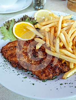 Wiener Schnitzel served with french fried potato and fresh salad