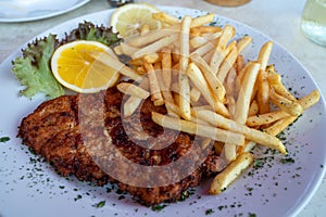 Wiener Schnitzel served with french fried potato and fresh salad