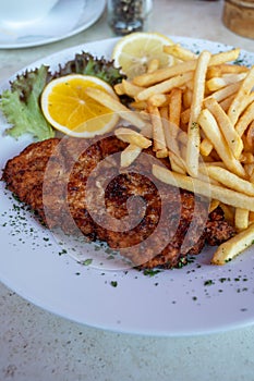 Wiener Schnitzel served with french fried potato and fresh salad