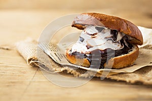 Wierd burger with vanilla ice cream and chocolated confetti on wooden background. photo
