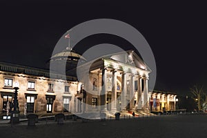 Wiesbaden casino with famous entrance with roman pillars by night