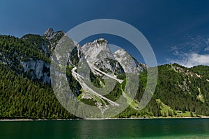 Wiew from lake shore up to well known ferrata in the Austrian Alps Intersport Klettersteig at Gosauseen or Vorderer Gosausee lake